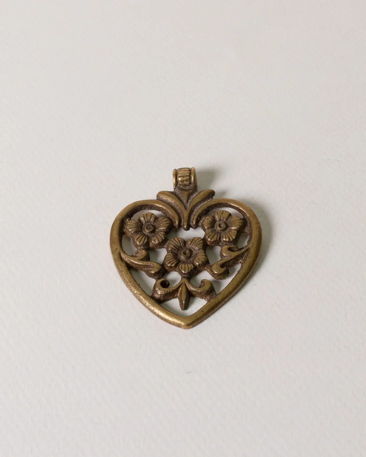 Corazón de bronce con tres flores dentro. Dorado